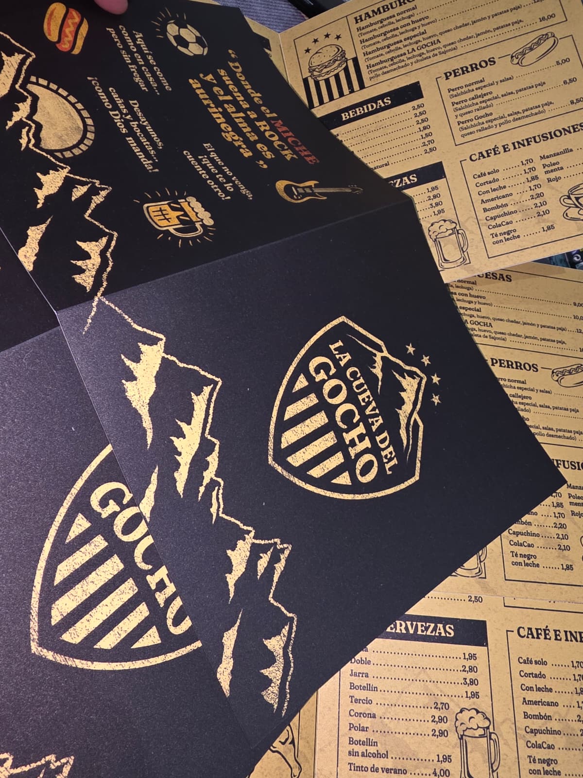Cartas de menú elegantes La Cueva del Gocho con diseño dorado sobre negro