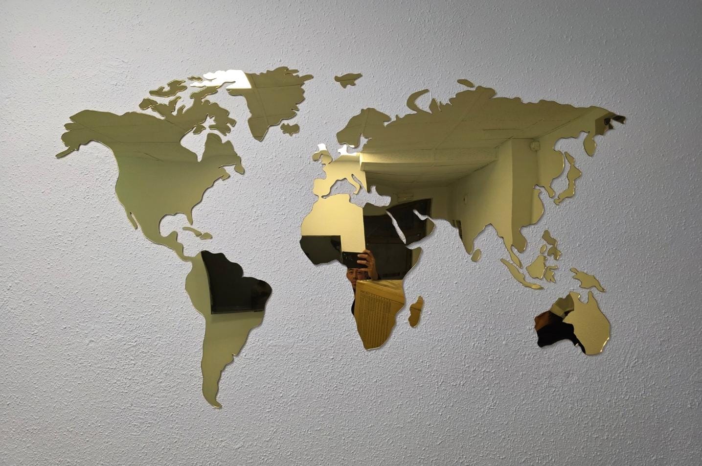 Mapamundi decorativo en metacrilato dorado sobre pared