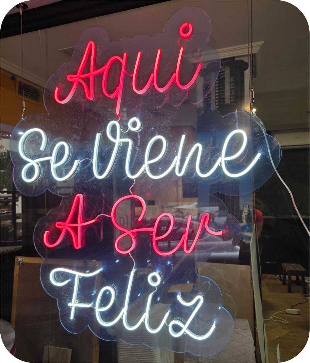 Neón rosa y blanco Aquí Se Viene A Ser Feliz colgante en escaparate