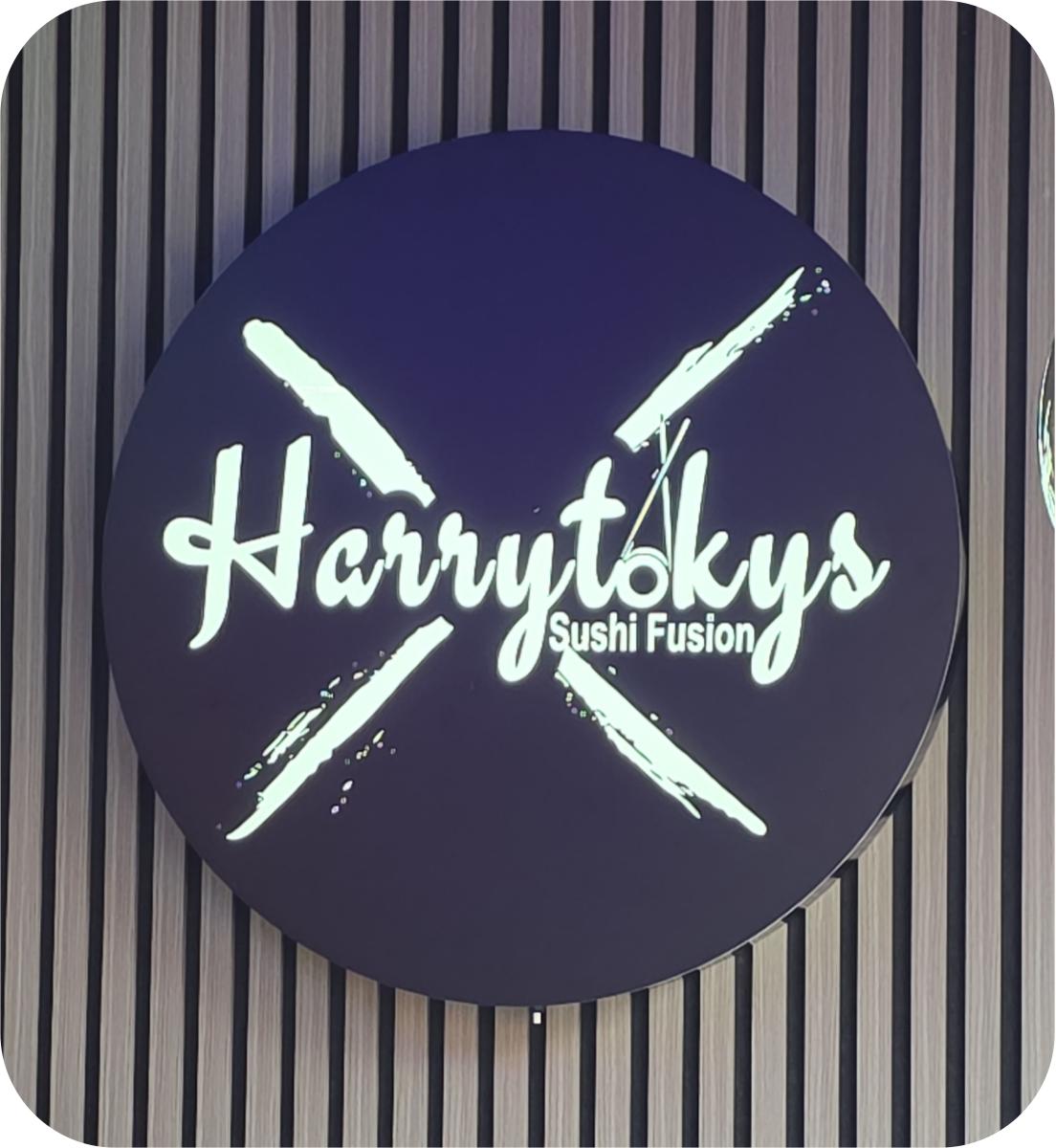 Rótulo circular luminoso Harrytokys sobre panel de listones