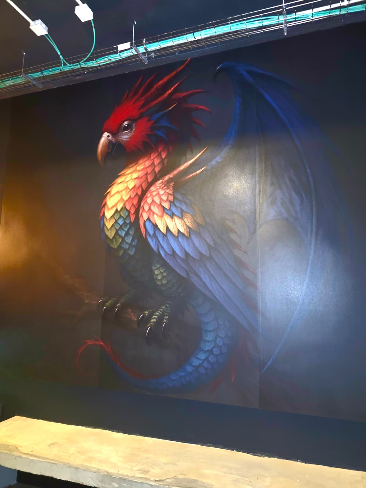 Mural artístico fénix pintado en local